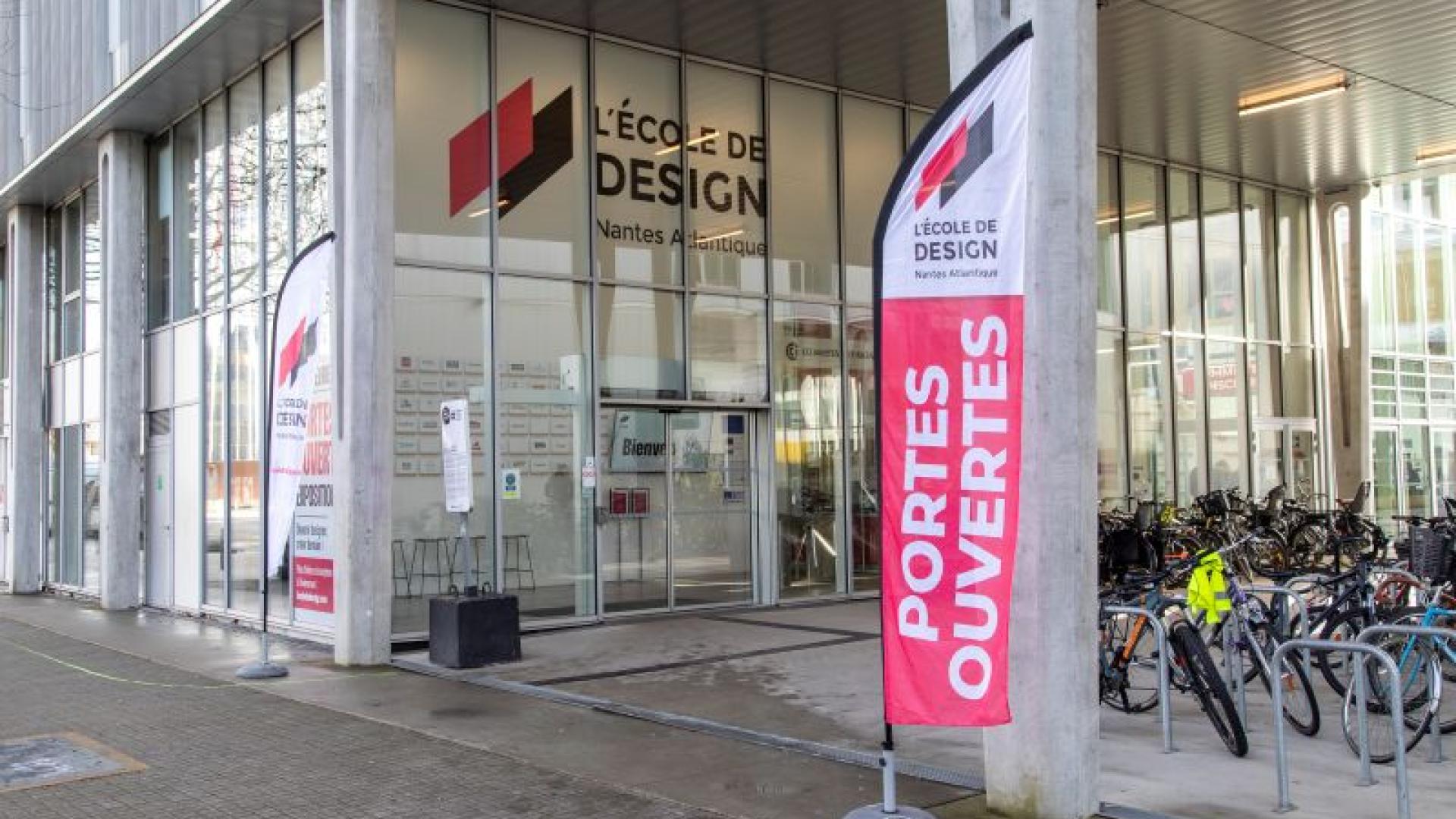 Photo de l'extérieur de l'école où l'on voit l'on l'entrée de l'école avec une flamme où s'est écrit : portes ouvertes